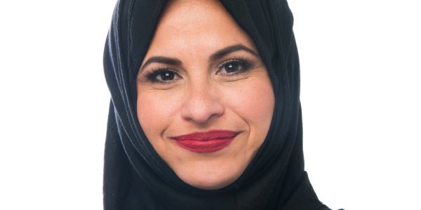 Smiling woman wearing a black hijab.