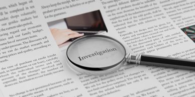 Magnifying glass highlighting the word 'Investigation' on a document.
