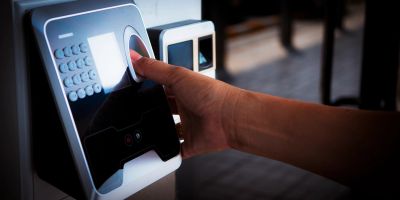 Person using fingerprint scanner for biometric identification.