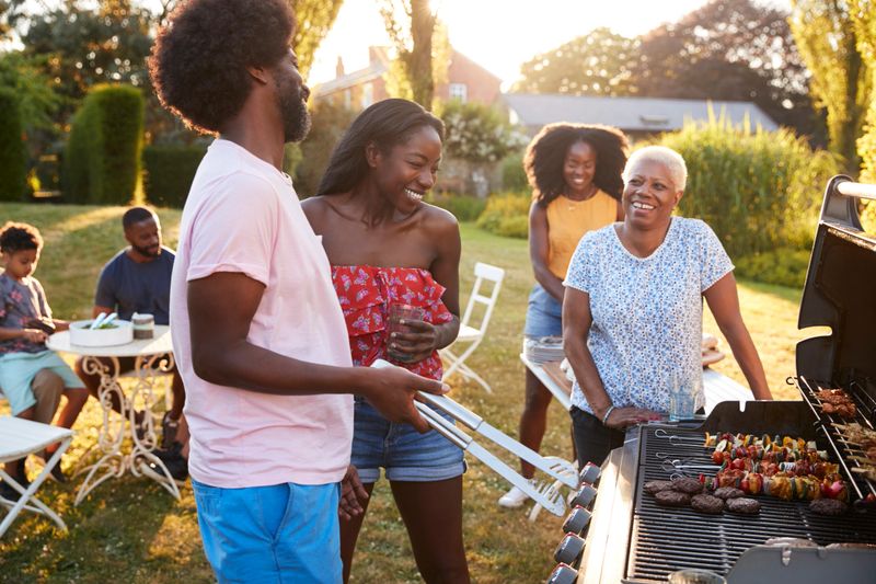 Adults talking at a multi generation family barbecue
