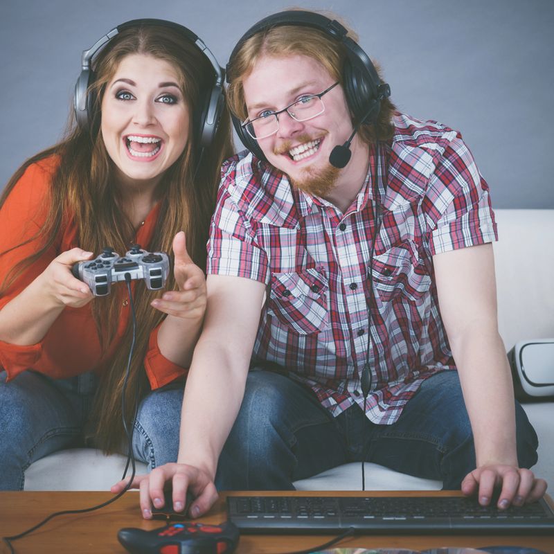 Happy couple enjoying leisure time by playing video games together. Studio shot