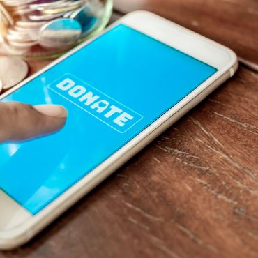 Finger about to tap a donate button on a smartphone screen.