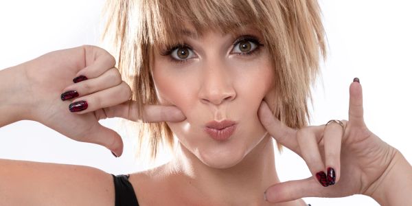 Woman making a playful face with hands framing her face.