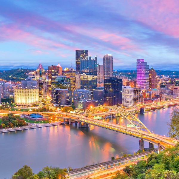 Pittsburgh skyline at sunset overlooking the rivers, highlighting major event venues downtown.
