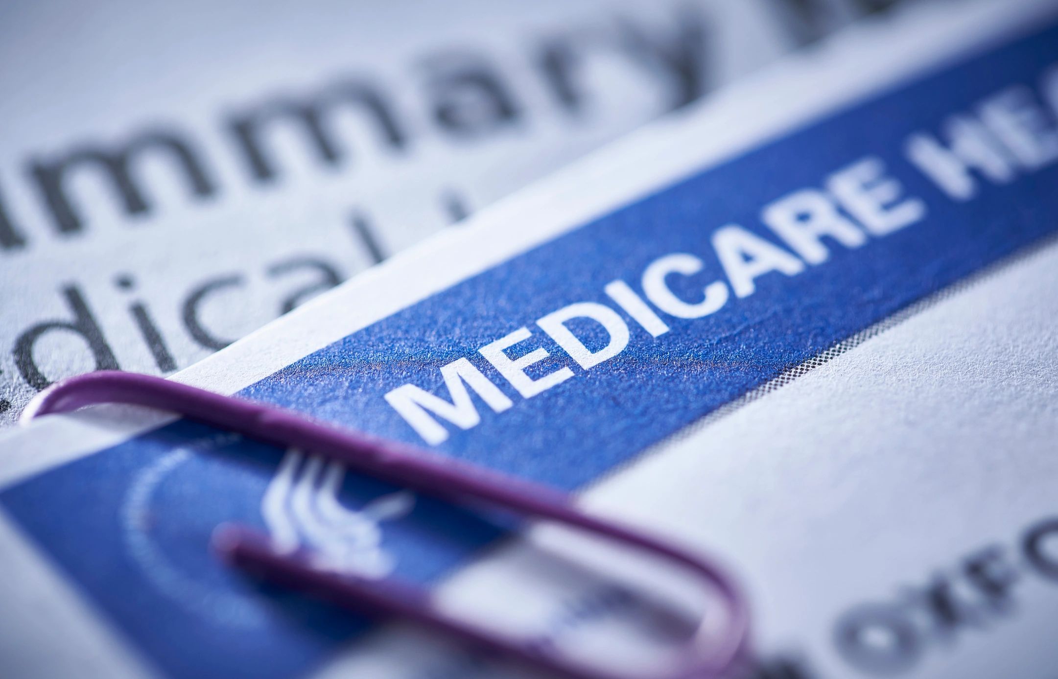 Close-up of Medicare card with a purple paperclip.