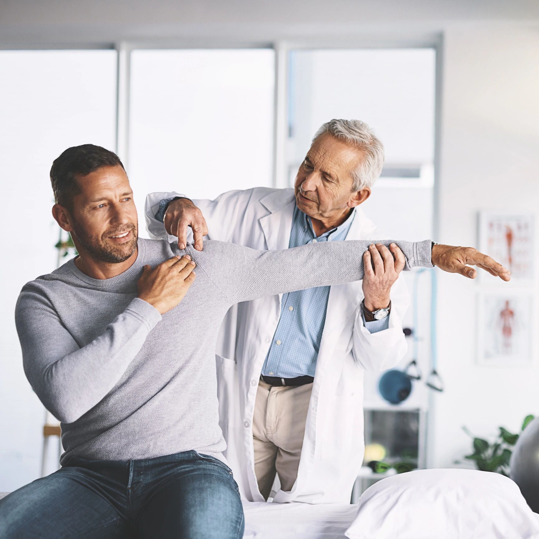 Doctor examining patient's shoulder and arm mobility.