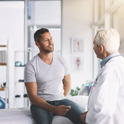 A man consulting with a doctor in a bright medical office.
