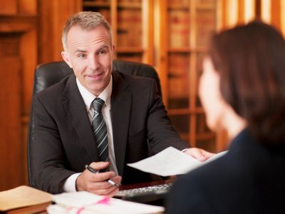 Man handing over a paper to a woman in an office.