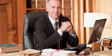 Confident businessman sitting at office desk.