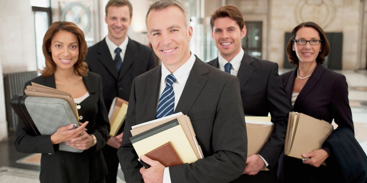 Group of business professionals smiling with documents.