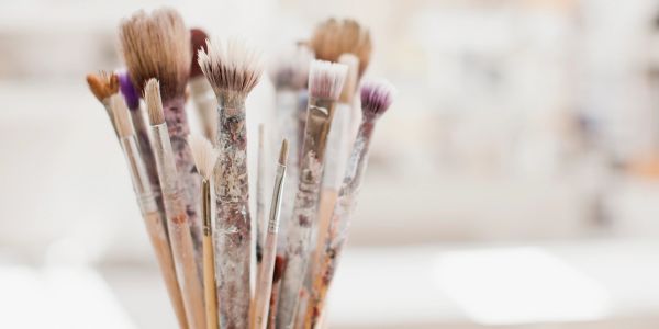 Close-up of paintbrushes with paint on them.