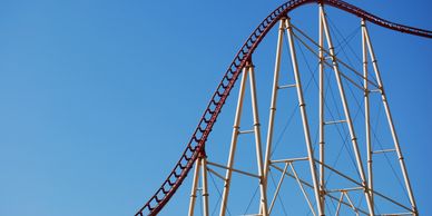 A towering roller coaster track against a clear blue sky.