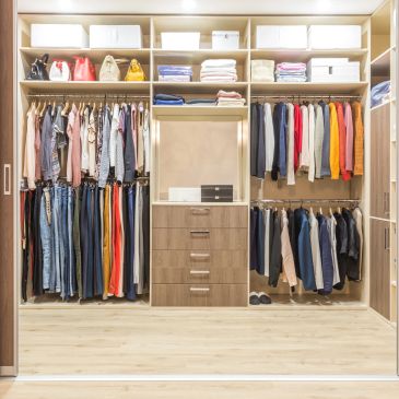 Organized walk-in closet with neatly arranged clothes and accessories.