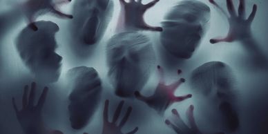 Silhouetted faces and hands pressing against a foggy surface.