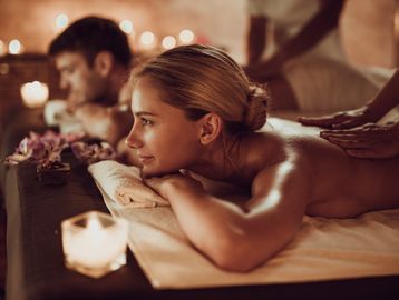 Couple receiving back massages in a relaxing spa setting.