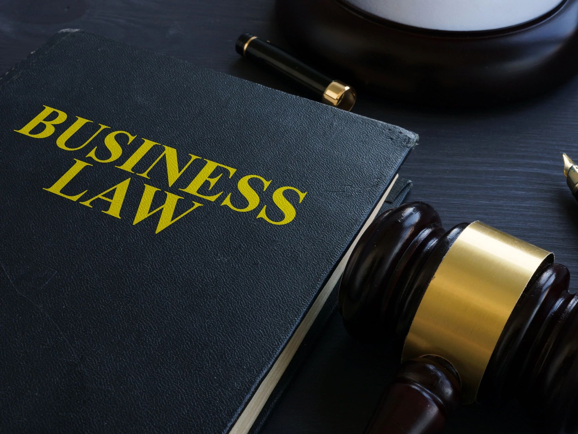Business law book with a gavel and pen.
