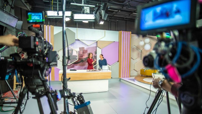 Photo of video recording equipment and stage in a studio during the filming of a TV show.