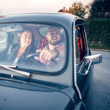 Happy couple enjoying a drive in a classic car.