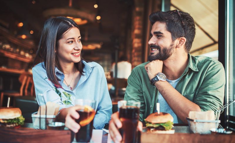 Happy loving couple enjoying breakfast in a cafe. Love, dating, food, lifestyle concept