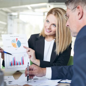 Businesswoman presenting sales analysis to colleagues in a meeting.