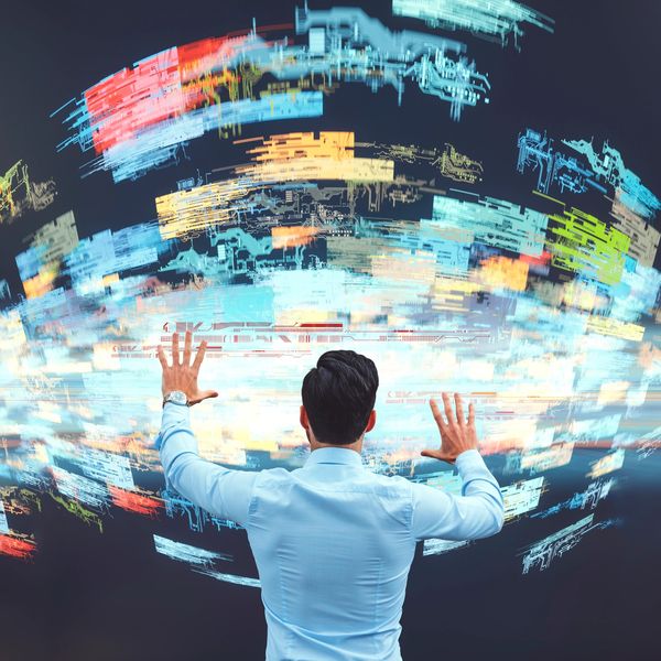 Man interacts with floating digital data holograms in a futuristic setting.