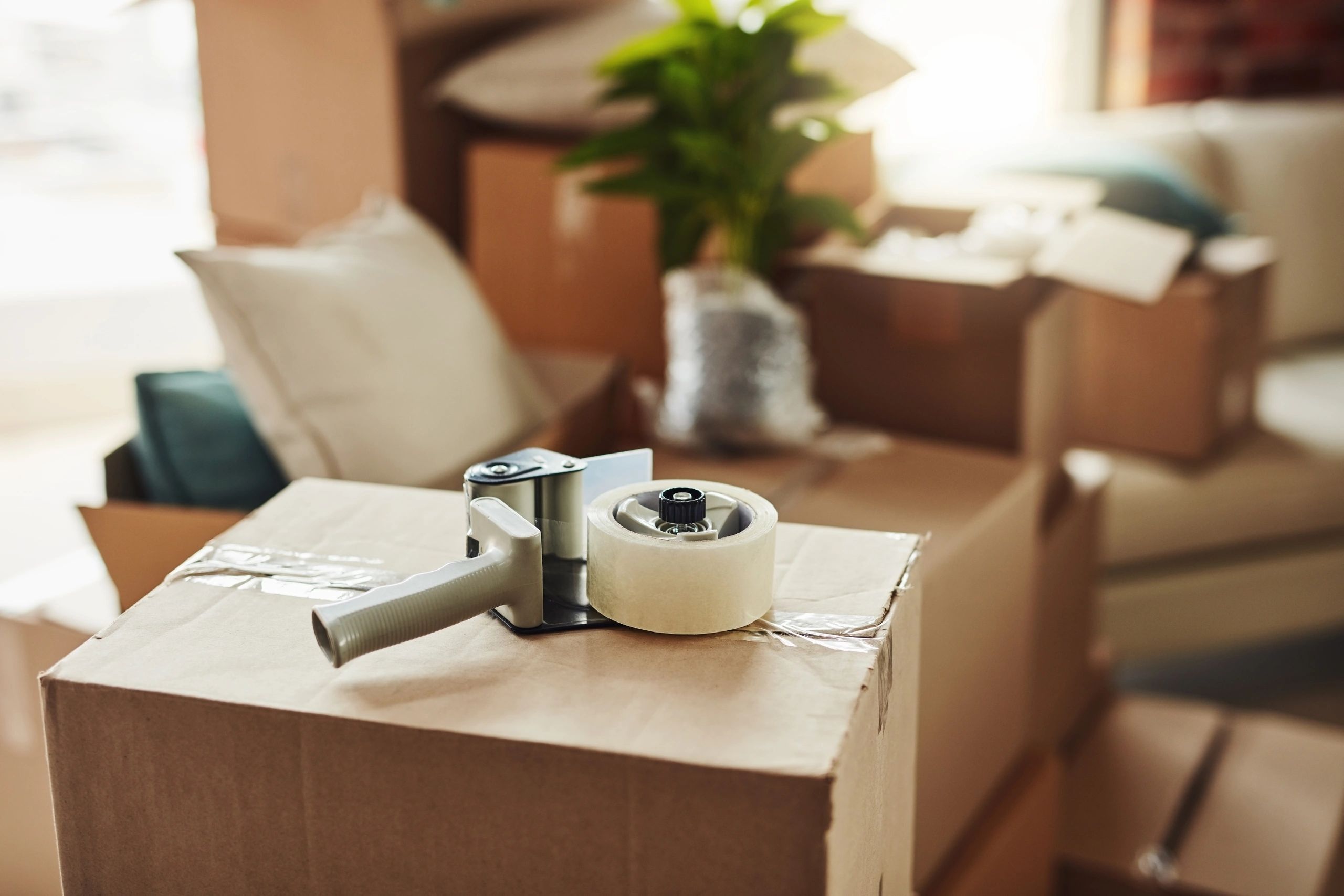 Packing tape dispenser on a moving box.