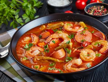 A bowl of shrimp and sausage gumbo garnished with parsley.