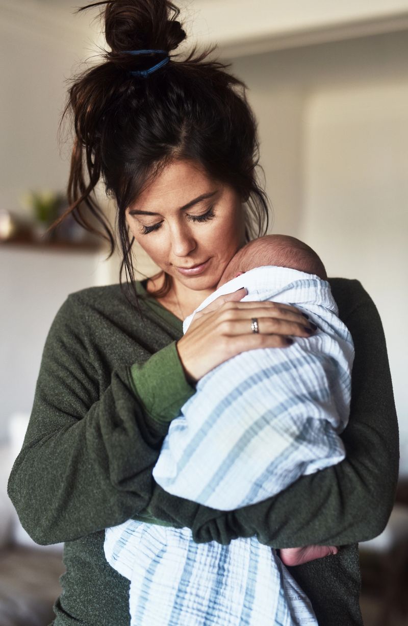 Shot of a cheerful young woman holding her little infant son at home during the day