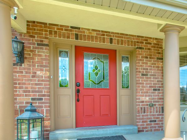 Front porch with a red door and decorative glass panels.