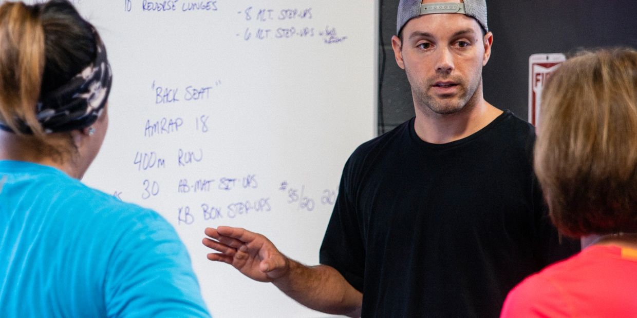 Fitness instructor explaining workout routine to participants.