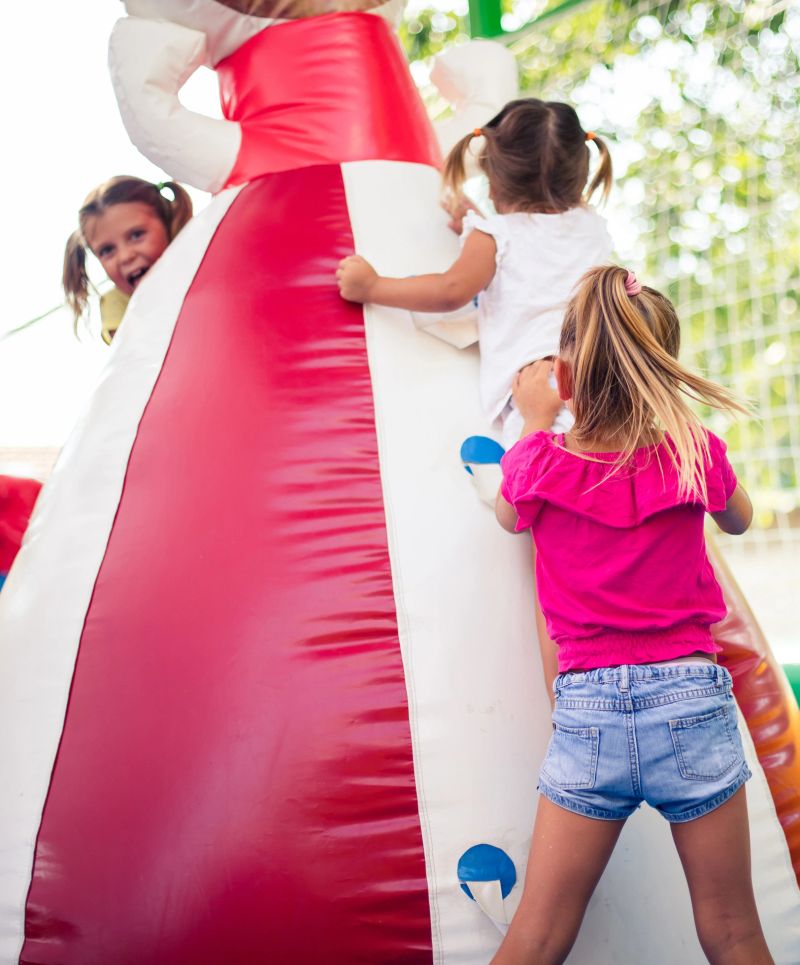 I help you. Three little girl playing together on playground. close up.