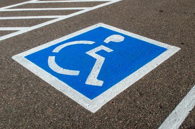Handicap parking space marked with blue and white paint on asphalt.