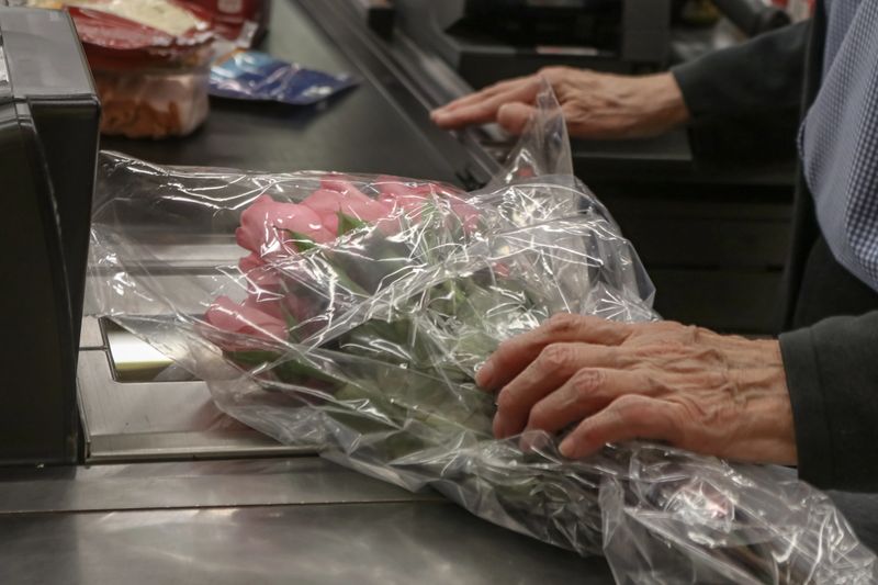 Elderly aged man buying boquet of pink roses at the store - cropped and selective focus