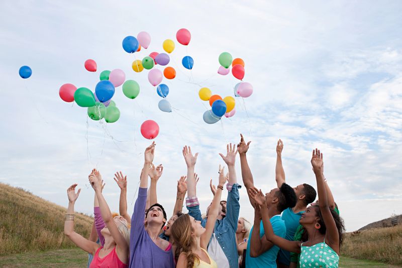 Young people releasing balloons