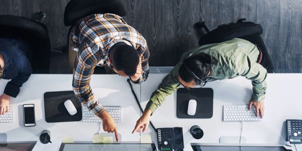 Two coworkers collaborating at a computer station.