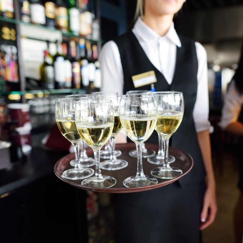 Waitress holding a dish of champagne and wine glasses at some festive event, party or wedding reception