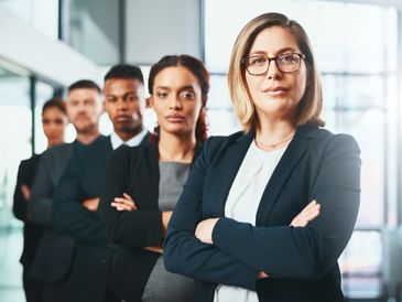 Businesswoman leading a meeting with colleagues in a modern office.
