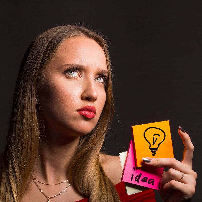 Concept of creative thinking and new ideas in business. Business woman blonde with long hair holding a marker and stickers for design thinking.