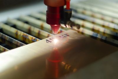 A laser engraver etching numbers onto a metal surface.