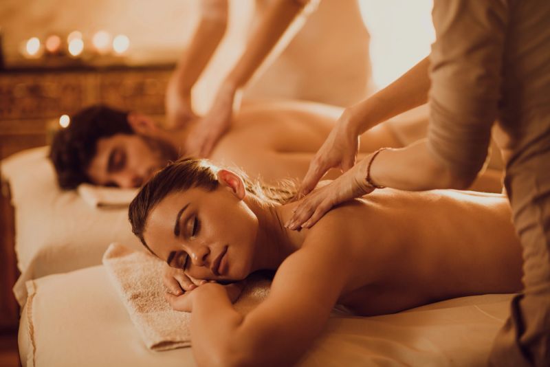 Young couple having back massage during their spa treatment.
