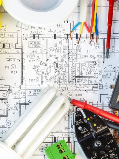 Electrical tools and components on a building blueprint.
