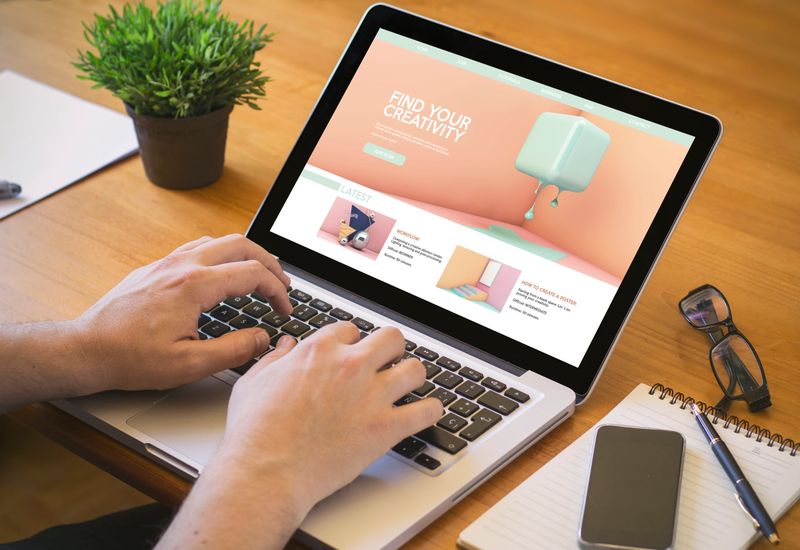 e-learning concept. Close-up top view of a man browsing a creativity tutorials on laptop. all screen graphics are made up.