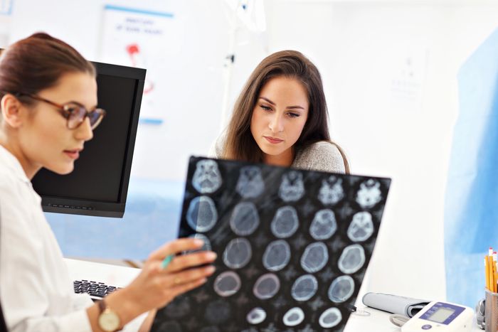 Doctor explaining brain scans to a concerned patient in a clinic.
