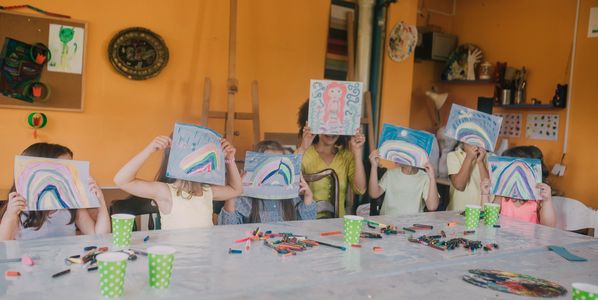 Young boy happily painting with bright colors indoors.