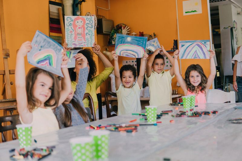 Group of school children holding up their paintings