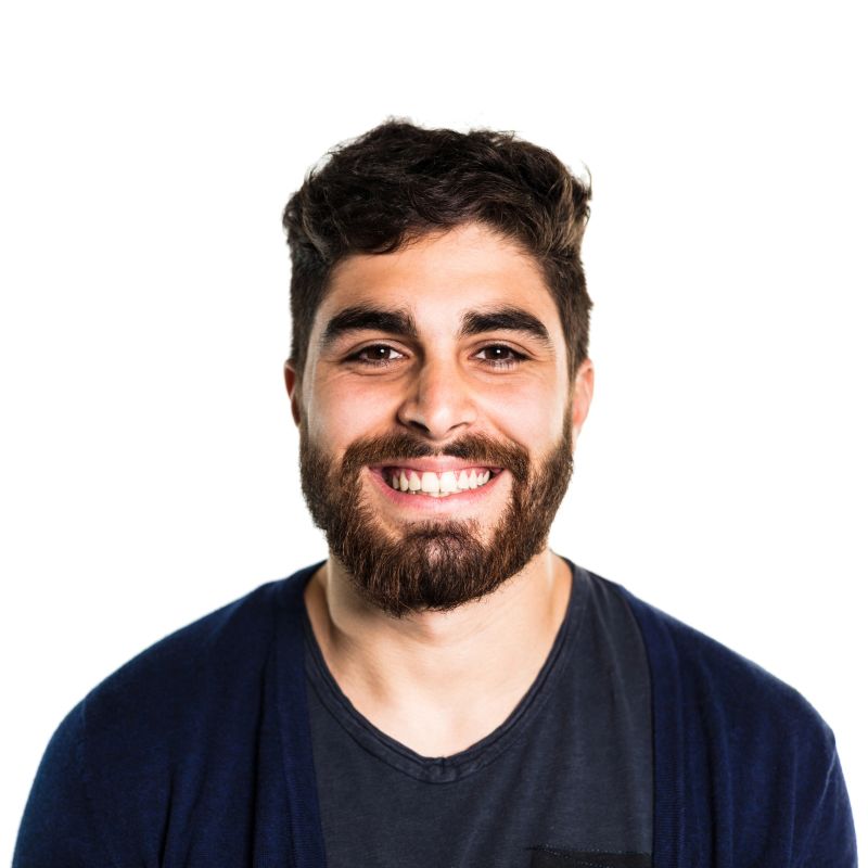 Portrait of smiling young man. Close-up of handsome male against white background. He is wearing casuals.