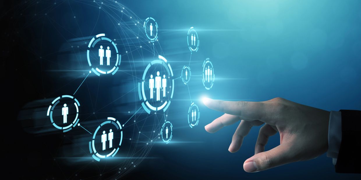 Hand interacting with digital network of people icons.