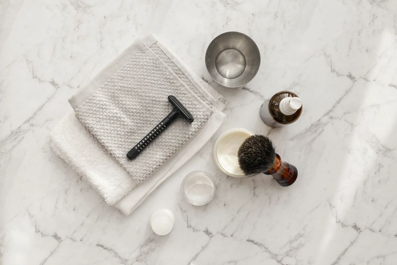 Shaving kit lying on clean, white, marble surface