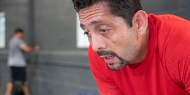 Tired man in red shirt catching his breath after workout.