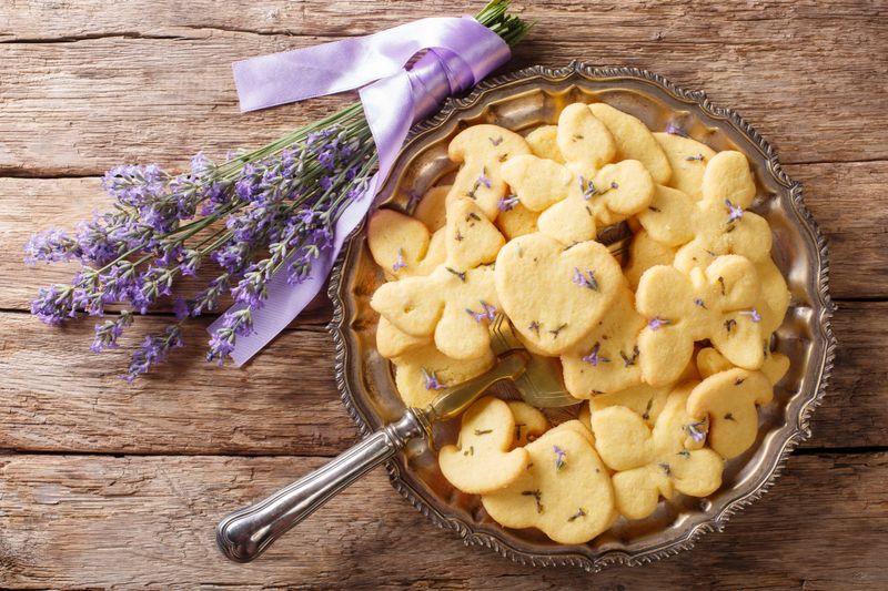 Delicious dessert food: lavender shortbread cookies close-up on a plate on the table. Horizontal top view from above